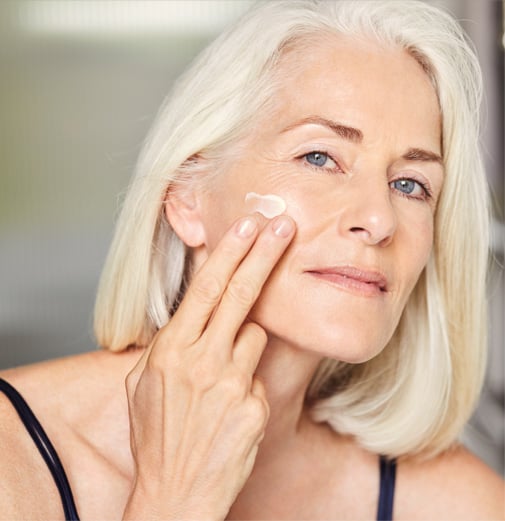 A mature women applying facial cream